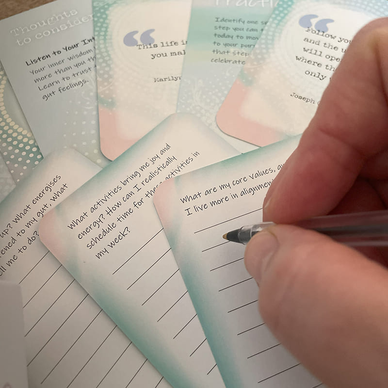 Finding My Purpose Journal Cards – close-up of hand journaling in response to a core values reflection prompt, surrounded by advice and quote cards.
